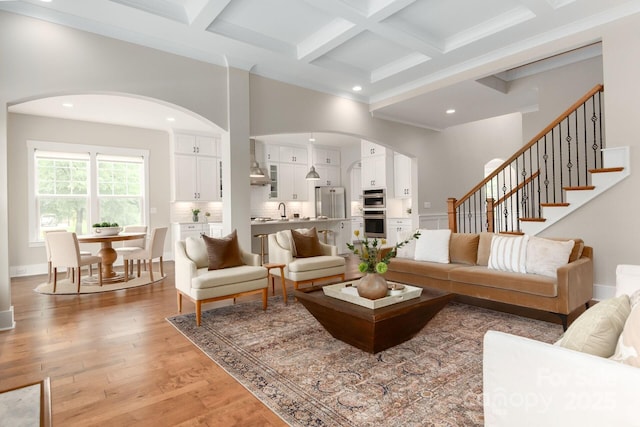 3009 Ocaso Ct, Matthews, NC 28104 - living area featuring arched walkways, coffered ceiling, beamed ceiling, a towering ceiling, and light wood finished floors