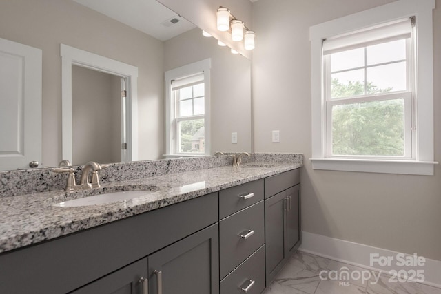 3009 Ocaso Ct, Matthews, NC 28104 - bathroom with double vanity, healthy amount of natural light, marble finish flooring, and baseboards