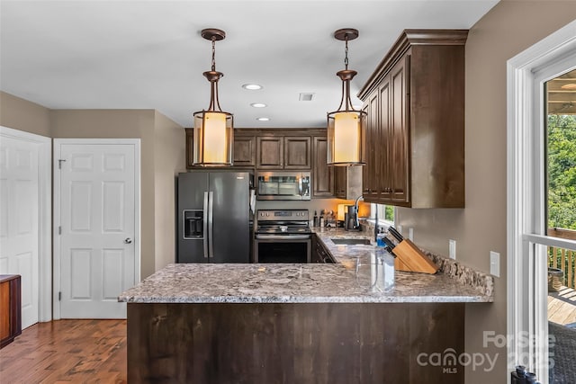 2508 Wolf Pit Rd, Morganton, NC 28655 - kitchen featuring appliances with stainless steel finishes, dark brown cabinets, a peninsula, dark wood-style floors, and light stone counters