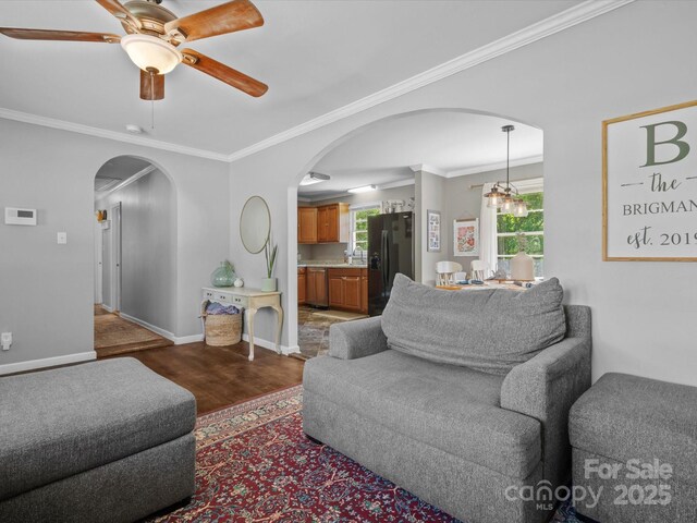2451 Robert H Kirk Rd, Lancaster, SC 29720 - living room featuring arched walkways, wood finished floors, crown molding, a ceiling fan, and baseboards