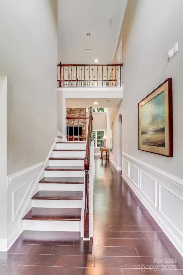 8070 Clems Branch Rd, Indian Land, SC 29707 - stairs with a decorative wall, arched walkways, wood finished floors, wainscoting, and recessed lighting