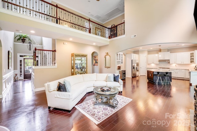 8070 Clems Branch Rd, Indian Land, SC 29707 - living room featuring arched walkways, a towering ceiling, beverage cooler, dark wood-style flooring, and ornamental molding