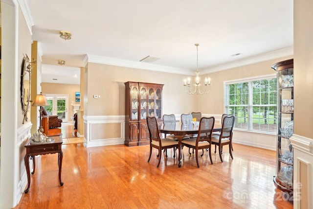 105 Prairie Rose Ct, Waxhaw, NC 28173 - dining space with light wood-style flooring, a chandelier, crown molding, baseboards, and a wainscoted wall