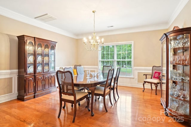 105 Prairie Rose Ct, Waxhaw, NC 28173 - dining area featuring a chandelier, light wood-style floors, wainscoting, and ornamental molding