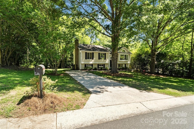 7018 Rollingridge Dr, Charlotte, NC 28211 - split foyer home featuring a chimney, a front lawn, and driveway