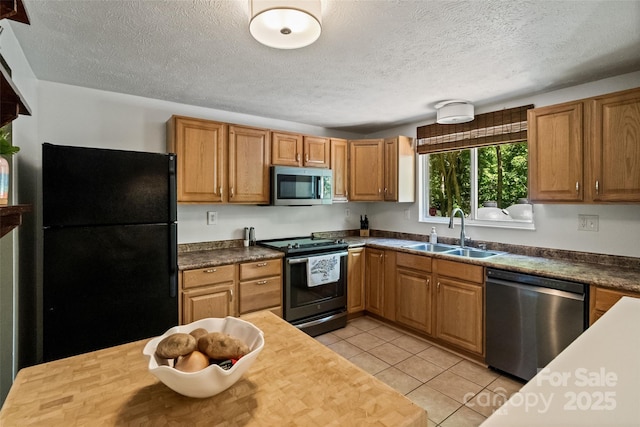 7018 Rollingridge Dr, Charlotte, NC 28211 - kitchen featuring stainless steel appliances, a sink, a textured ceiling, light tile patterned flooring, and brown cabinetry