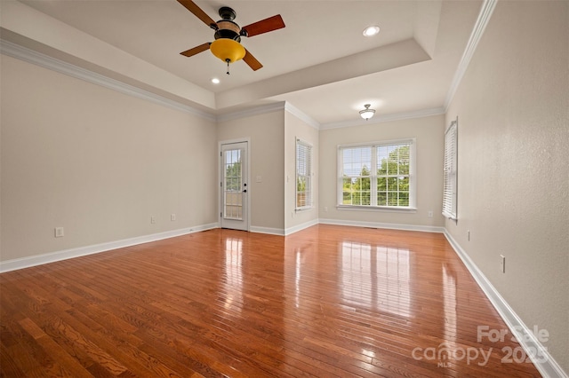 182 Kensington Dr, Forest City, NC 28043 - unfurnished living room with hardwood / wood-style floors, plenty of natural light, a ceiling fan, a tray ceiling, and ornamental molding