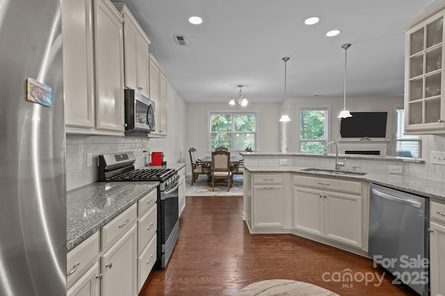 308 Planters Way, Mount Holly, NC 28120 - kitchen with stainless steel appliances, a sink, dark wood-type flooring, backsplash, and a peninsula