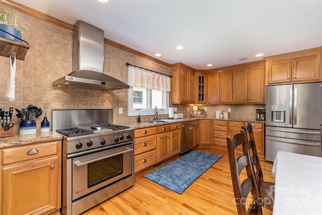 141 Eastover Dr SE, Concord, NC 28025 - kitchen featuring appliances with stainless steel finishes, wall chimney exhaust hood, a sink, tasteful backsplash, and light wood-style floors