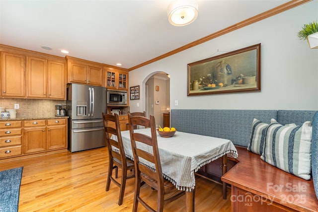 141 Eastover Dr SE, Concord, NC 28025 - dining space with arched walkways, light wood-type flooring, crown molding, a wainscoted wall, and recessed lighting