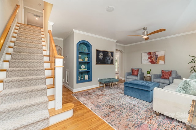 141 Eastover Dr SE, Concord, NC 28025 - living area with arched walkways, wood finished floors, crown molding, stairs, and built in features