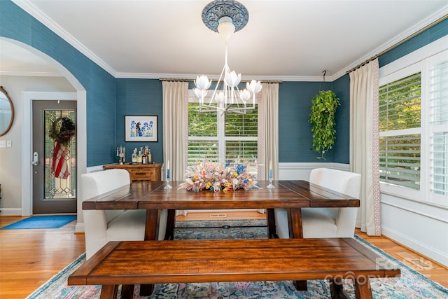 141 Eastover Dr SE, Concord, NC 28025 - dining space with a chandelier, crown molding, wood finished floors, arched walkways, and wallpapered walls
