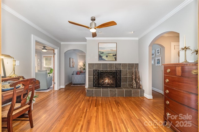 141 Eastover Dr SE, Concord, NC 28025 - living area featuring ceiling fan, light wood-style floors, crown molding, baseboards, and a fireplace