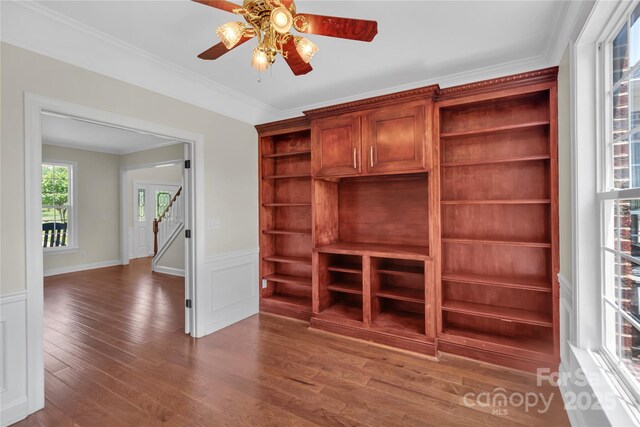 3068 River Rd, Shelby, NC 28152 - unfurnished living room featuring stairs, wood finished floors, ceiling fan, crown molding, and a wainscoted wall
