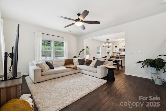 5113 Saddleback Dr, Mount Holly, NC 28120 - living area with dark wood-style flooring, ceiling fan, a chandelier, and baseboards