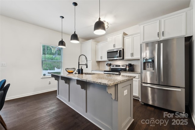 5113 Saddleback Dr, Mount Holly, NC 28120 - kitchen featuring appliances with stainless steel finishes, a sink, an island with sink, dark wood-style floors, and white cabinets