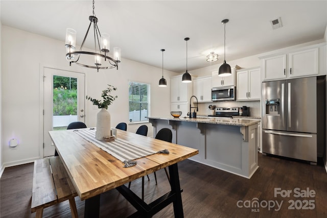 5113 Saddleback Dr, Mount Holly, NC 28120 - dining area featuring healthy amount of natural light, dark wood-style floors, and a chandelier