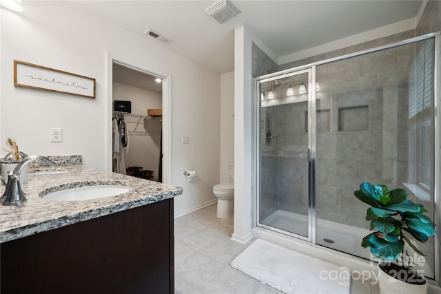 5113 Saddleback Dr, Mount Holly, NC 28120 - bathroom with a walk in closet, a stall shower, vanity, toilet, and tile patterned floors
