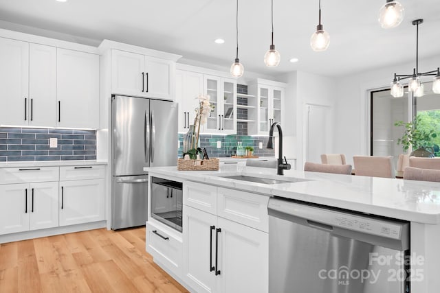 106 Arbor Dr, Waxhaw, NC 28173 - kitchen featuring appliances with stainless steel finishes, a sink, recessed lighting, tasteful backsplash, and glass insert cabinets