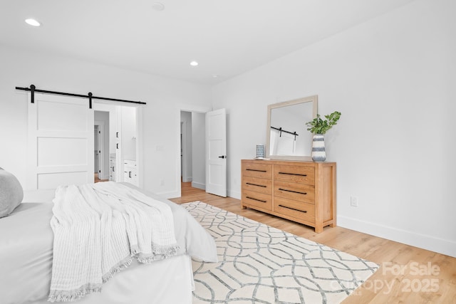 106 Arbor Dr, Waxhaw, NC 28173 - bedroom featuring a barn door, light wood-style floors, baseboards, and recessed lighting