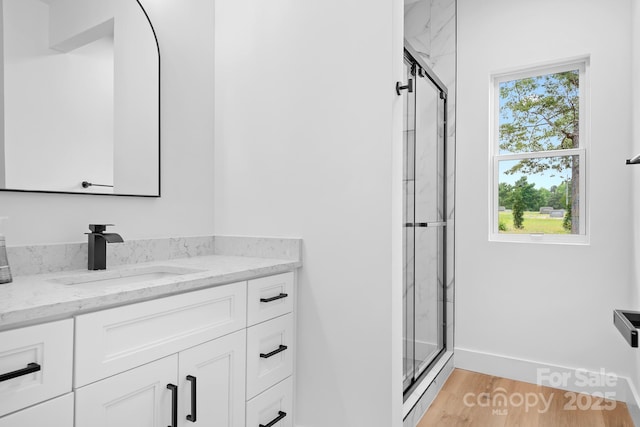 106 Arbor Dr, Waxhaw, NC 28173 - bathroom featuring vanity, a shower stall, wood finished floors, and baseboards