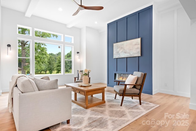 106 Arbor Dr, Waxhaw, NC 28173 - living room featuring a ceiling fan, beam ceiling, light wood finished floors, a fireplace, and a decorative wall