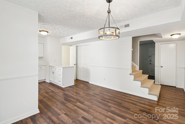 8510 Castle Pine Ct, Charlotte, NC 28226 - unfurnished dining area with dark wood finished floors, a chandelier, baseboards, stairway, and a textured ceiling