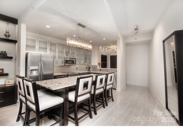 333 W Trade St Unit 1304, Charlotte, NC 28202 - kitchen with stainless steel appliances, tasteful backsplash, a breakfast bar, light wood-style floors, and recessed lighting