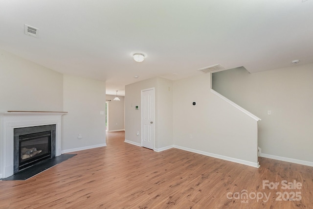 8524 Emerald Fern Way, Charlotte, NC 28214 - unfurnished living room featuring light wood finished floors, baseboards, and a glass covered fireplace