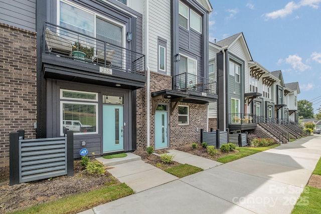 235 S Bruns Ave, Charlotte, NC 28208 - view of front facade with a balcony, brick siding, and a residential view
