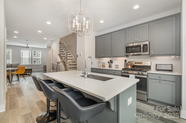 235 S Bruns Ave, Charlotte, NC 28208 - kitchen featuring appliances with stainless steel finishes, a sink, gray cabinetry, light wood finished floors, and recessed lighting