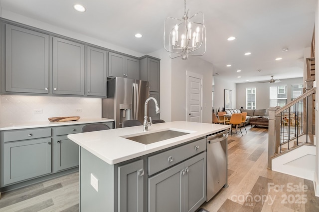 235 S Bruns Ave, Charlotte, NC 28208 - kitchen with gray cabinetry, a sink, stainless steel appliances, light wood-style flooring, and recessed lighting