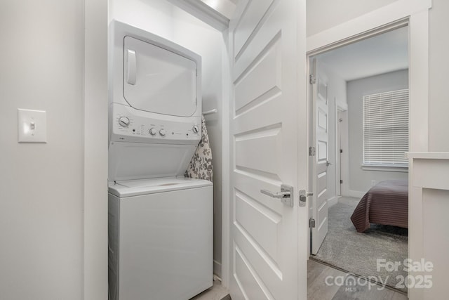 235 S Bruns Ave, Charlotte, NC 28208 - laundry area with stacked washing machine and dryer, baseboards, and light carpet