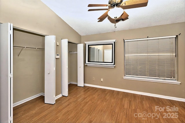 6401 Windsor Gate Ln, Charlotte, NC 28215 - unfurnished bedroom featuring wood finished floors, vaulted ceiling, multiple closets, baseboards, and ceiling fan