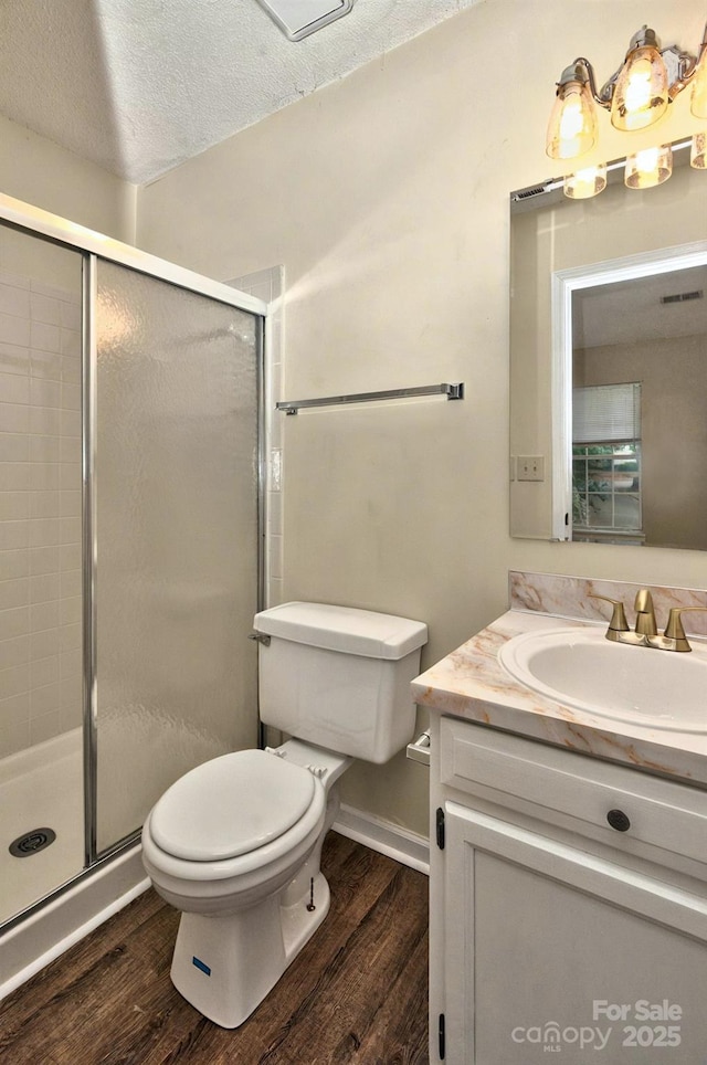 6401 Windsor Gate Ln, Charlotte, NC 28215 - bathroom with toilet, wood finished floors, vanity, a shower stall, and a textured ceiling