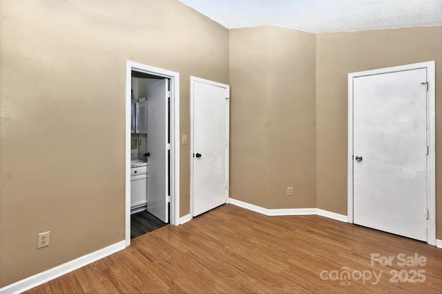 6401 Windsor Gate Ln, Charlotte, NC 28215 - unfurnished bedroom featuring wood finished floors, baseboards, and connected bathroom