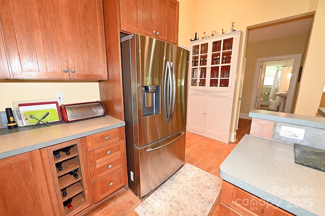 616 N Deal Ave, Newton, NC 28658 - kitchen with stainless steel fridge with ice dispenser, light wood-type flooring, brown cabinets, and light countertops