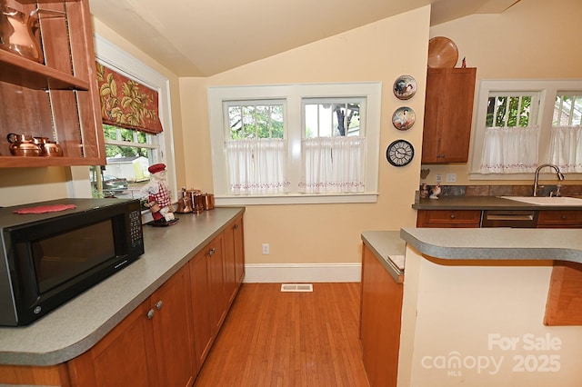 616 N Deal Ave, Newton, NC 28658 - kitchen with black microwave, light wood-type flooring, lofted ceiling, brown cabinetry, and a sink