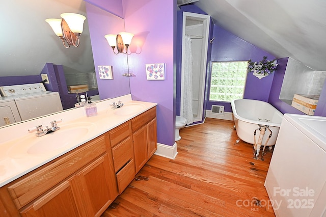 616 N Deal Ave, Newton, NC 28658 - full bathroom featuring washing machine and dryer, wood finished floors, double vanity, lofted ceiling, and a soaking tub