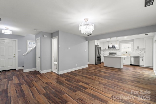 3124 Pikes Peak Dr, Gastonia, NC 28052 - kitchen featuring stainless steel appliances, baseboards, a chandelier, white cabinetry, and plenty of natural light