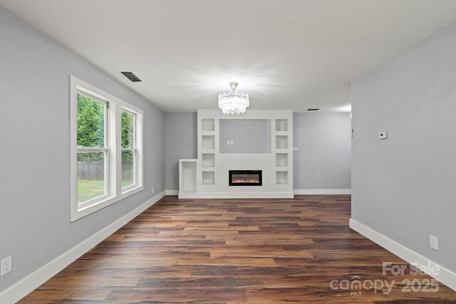 3124 Pikes Peak Dr, Gastonia, NC 28052 - unfurnished living room featuring healthy amount of natural light, a chandelier, and baseboards