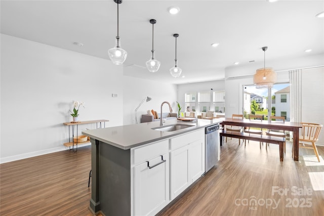 3938 Isenhour Rd, Kannapolis, NC 28081 - kitchen featuring a sink, stainless steel dishwasher, wood finished floors, a kitchen island with sink, and decorative light fixtures