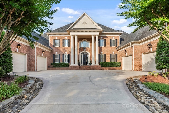 8721 Lake Challis Ln, Charlotte, NC 28226 - neoclassical home with driveway, brick siding, and an attached garage
