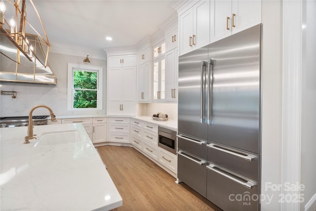 8721 Lake Challis Ln, Charlotte, NC 28226 - kitchen featuring built in appliances, white cabinets, light wood-style floors, backsplash, and glass insert cabinets