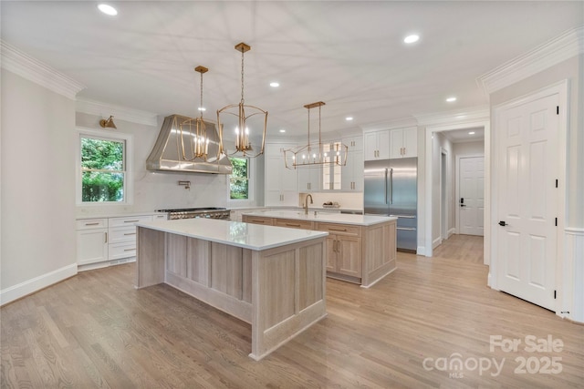 8721 Lake Challis Ln, Charlotte, NC 28226 - kitchen with a center island with sink, exhaust hood, stainless steel built in fridge, crown molding, and light countertops