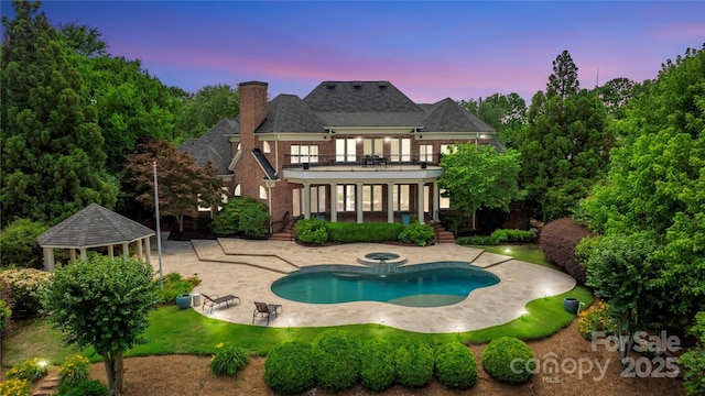 8721 Lake Challis Ln, Charlotte, NC 28226 - rear view of house with a balcony, a gazebo, a patio area, a chimney, and a pool with connected hot tub