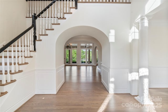 8721 Lake Challis Ln, Charlotte, NC 28226 - foyer entrance with arched walkways, a decorative wall, a wainscoted wall, light wood finished floors, and a high ceiling