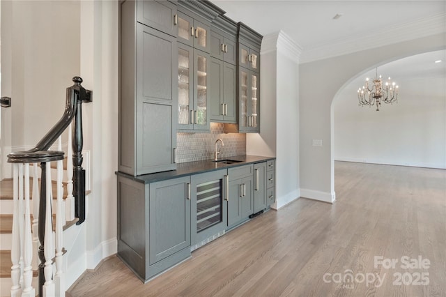 8721 Lake Challis Ln, Charlotte, NC 28226 - bar area featuring arched walkways, wine cooler, backsplash, light wood-style flooring, and crown molding