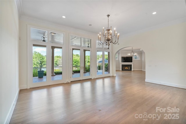 8721 Lake Challis Ln, Charlotte, NC 28226 - unfurnished living room featuring a chandelier, wood finished floors, arched walkways, ornamental molding, and recessed lighting