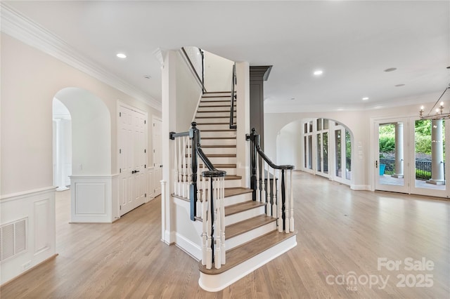 8721 Lake Challis Ln, Charlotte, NC 28226 - stairway with ornamental molding, arched walkways, wood finished floors, wainscoting, and recessed lighting